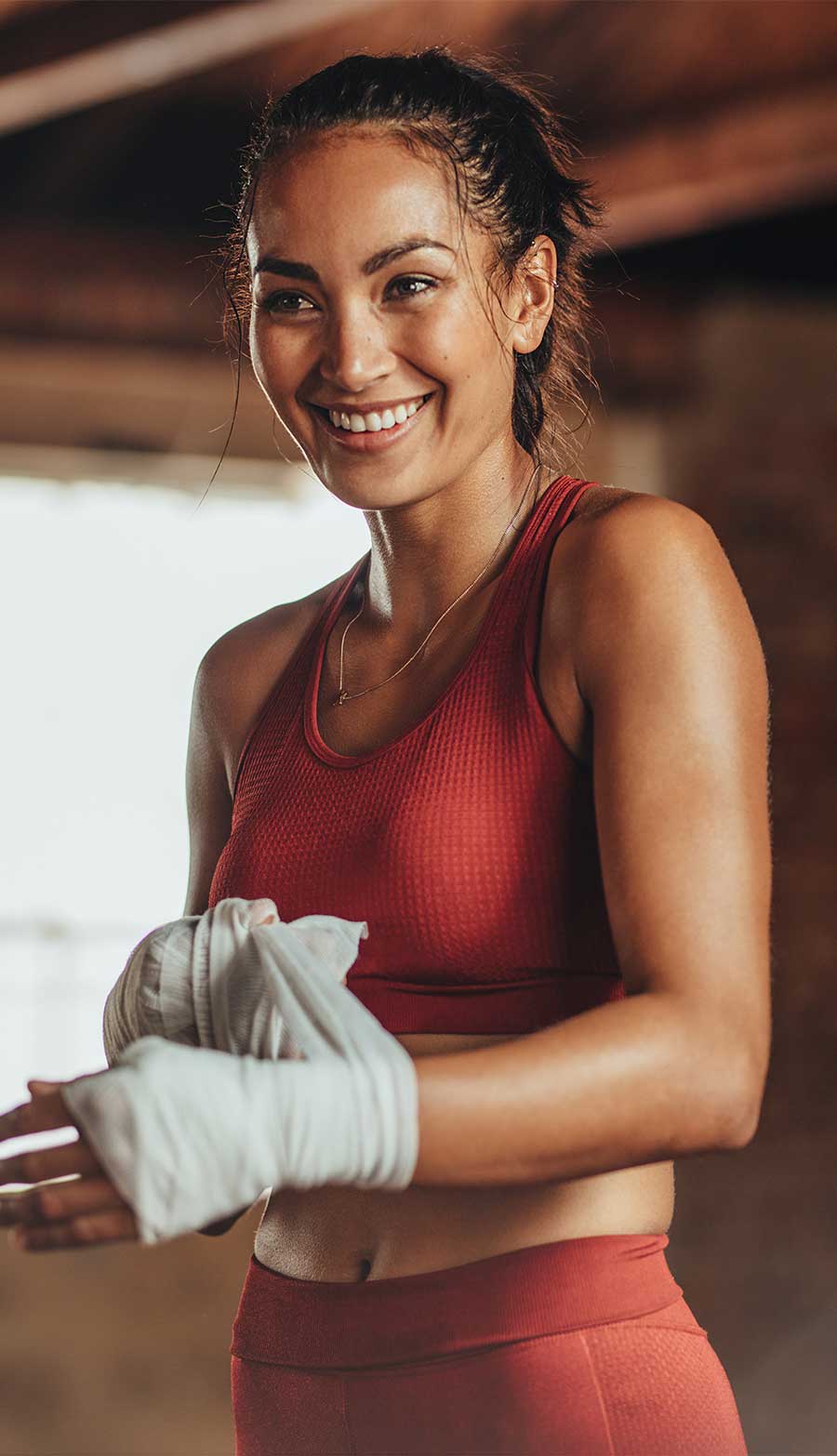 jeune femme souriante qui va démarrer son premier cours de boxe
