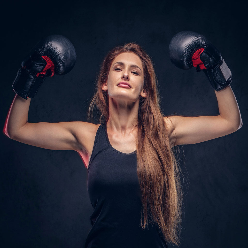 Une femme avec des gants de boxe qui a gagné son combat