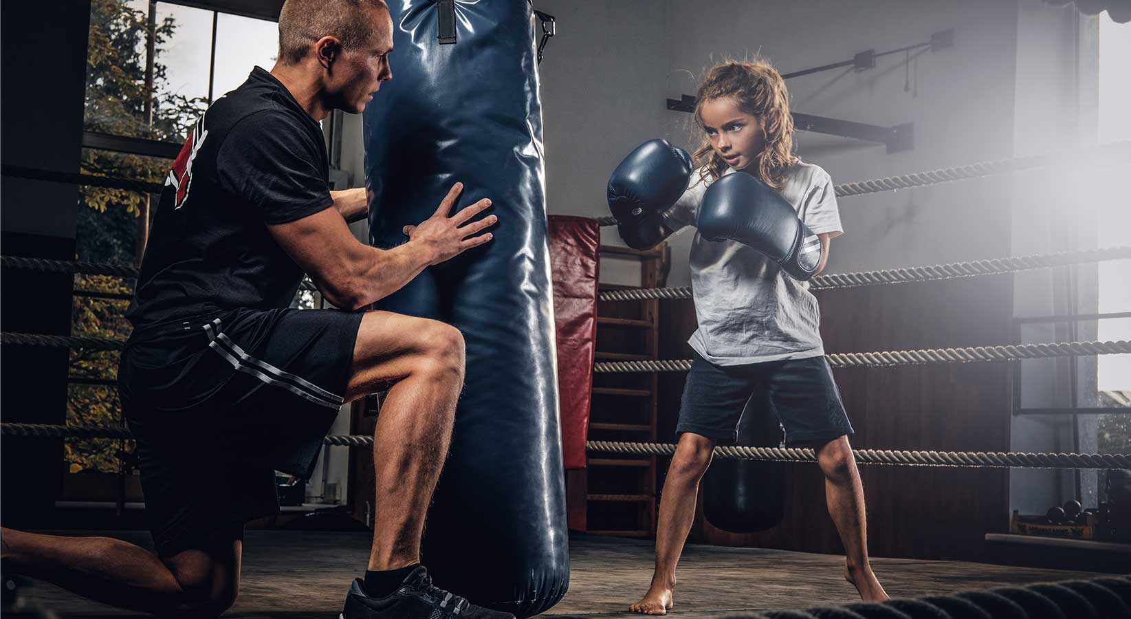 jeune fille apprenant la boxe avec son coach privé