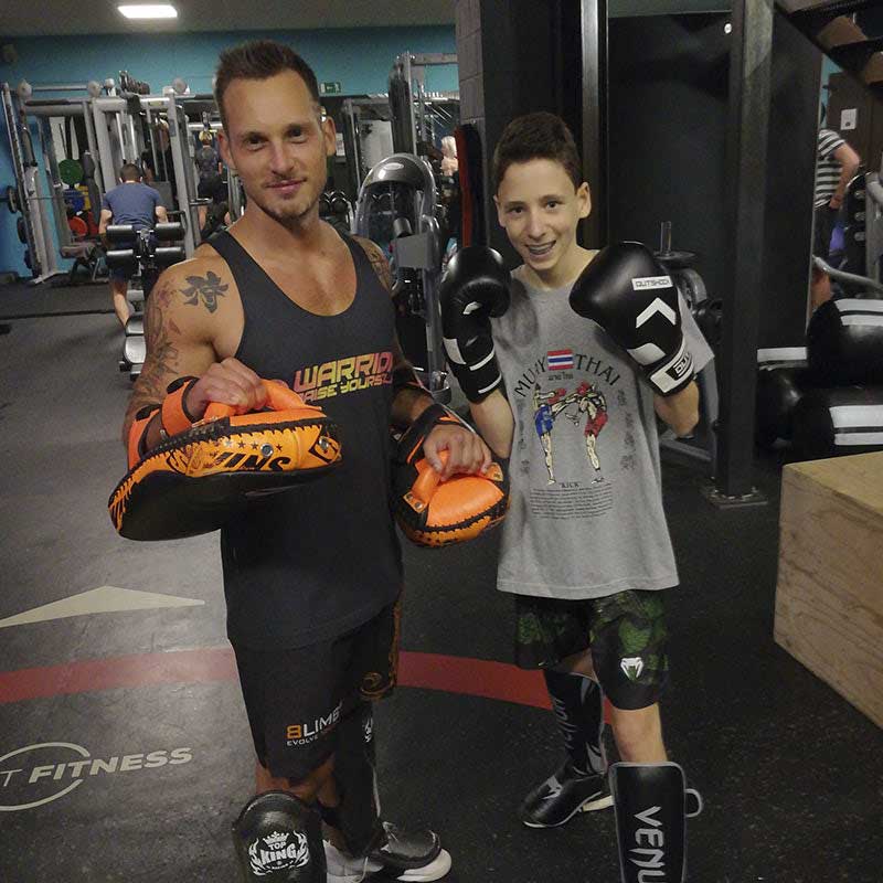 Un jeune élève et son moniteur de boxe dans une salle de sport